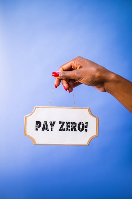 A close-up of a person's hand with red-painted nails holding a small rectangular wooden sign by a thin string. The sign displays the message 'PAY ZERO!' in bold, black capital letters on a plain white background. The hand is positioned against a solid bright blue background, with the fingers gently pinching the string. This image conveys a message of cost-saving, which may relate to transparent or no hidden charges in house removals and relocation services offered by Man with Van Sands End, whose website is visible for more information about their moving and furniture transport solutions.