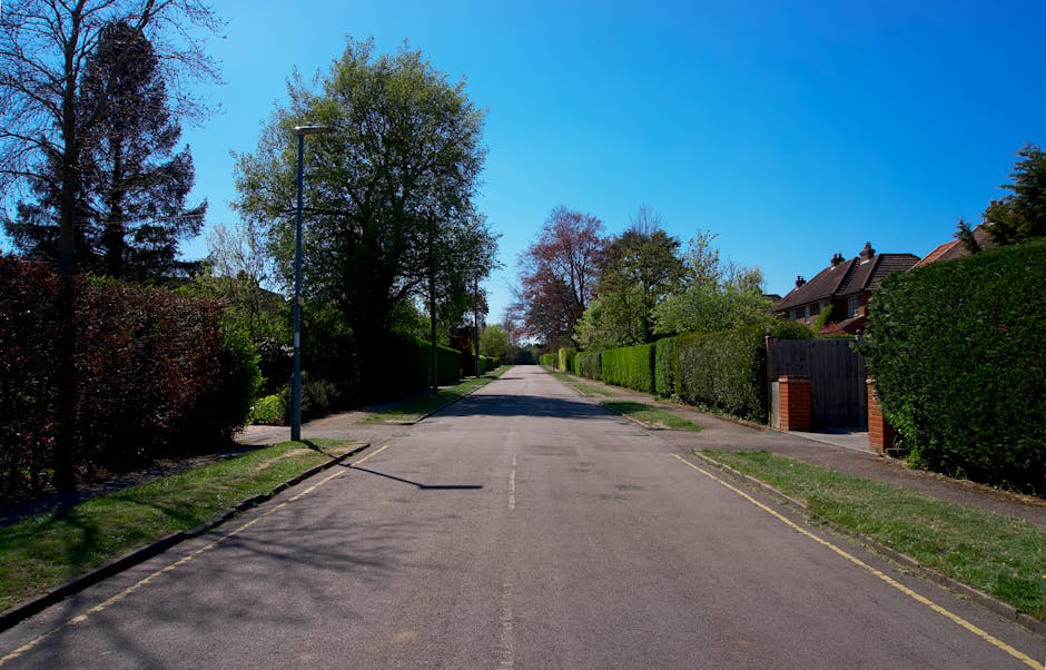 A quiet residential street in Sands End with terraced houses on both sides, featuring brick facades, bay windows, and chimneys. Several parked cars, including a small van with a rear ramp lowered for 